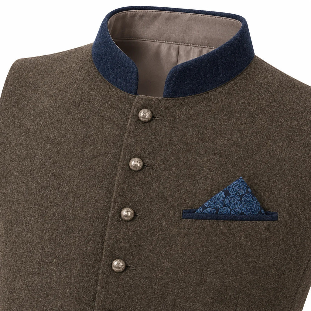 A close-up of a men's traditional-style jacket or waistcoat in textured brown fabric, featuring a dark navy blue mandarin collar, silver-tone front buttons, and a matching navy blue patterned pocket square.