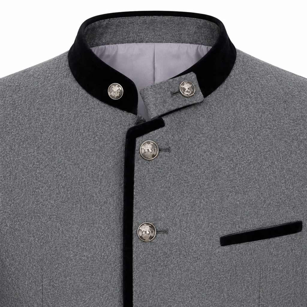 Close-up of a gray textured jacket with black velvet trim on the collar and front placket, plus decorative silver-tone buttons and a black pocket flap.
